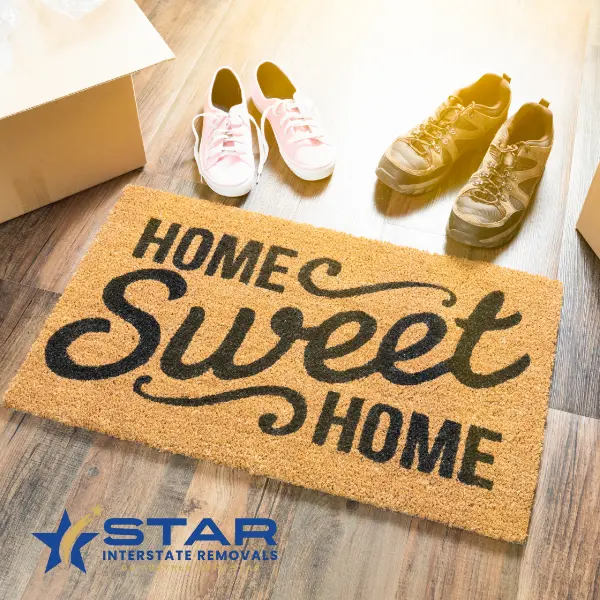 Smiling couple holding a box with Star Interstate Removals logo