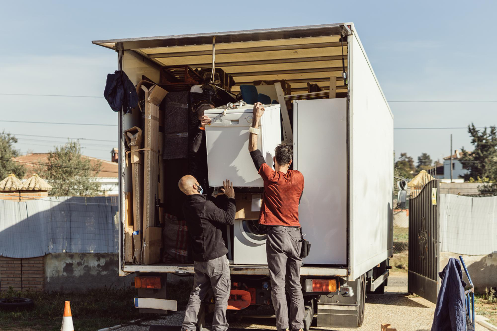Movers securing large household items in a moving truck