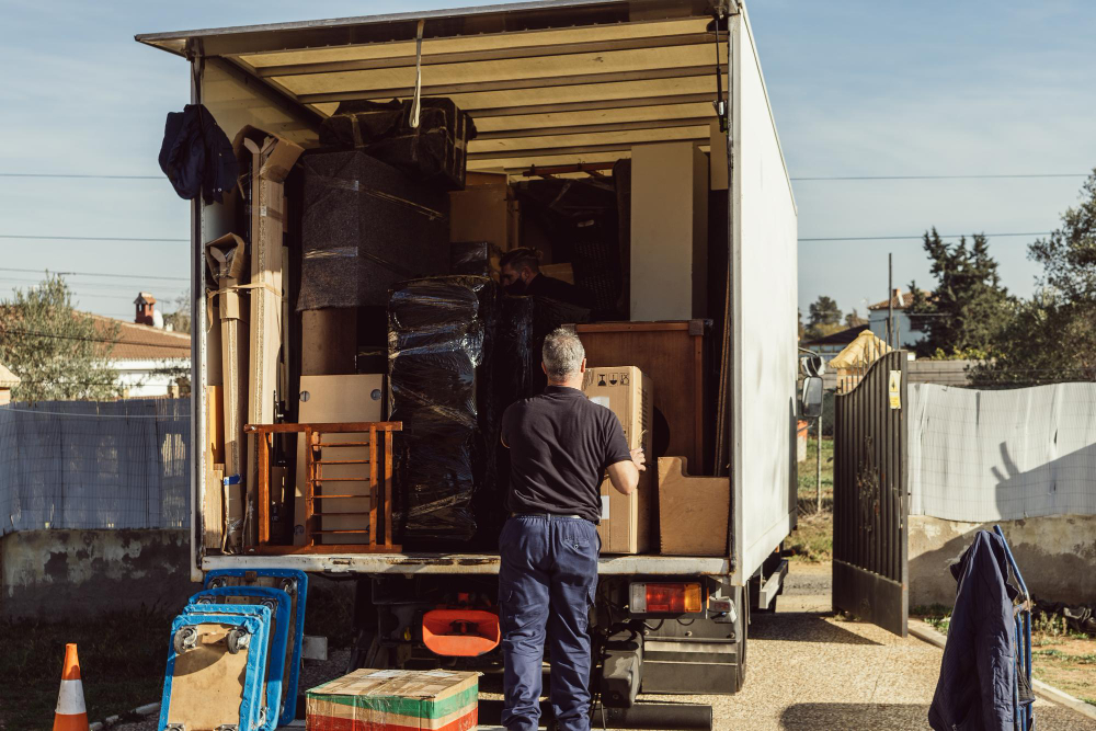 Man organizing items in the back of a moving truck